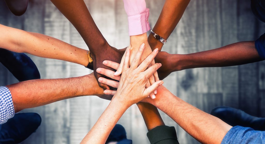 Close up view of young business people putting their hands toget